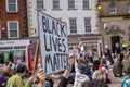 A Black Lives Matter placard is held up above a kneeling crowd at a protest in Richmond, North Yorkshire