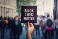 Black Lives Matter, street demonstration. Human hand holds a dark protest banner, against injustice. USA black people rights,