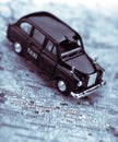 Black London taxi cab on street map of London Royalty Free Stock Photo