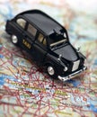 Black London taxi cab on street map of London Royalty Free Stock Photo