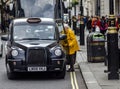 Black London taxi in traffic, big city, street view