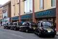 Black London Taxis Parked Outside A Primark Department Store In A Town Centre High Street