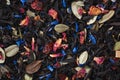 Black loose leaf tea texture with dried fruits, herbs and flower petals