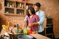 Black love couple cooking together on the kitchen