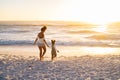 Black lovely mother and daughter walking on beach at sunset Royalty Free Stock Photo