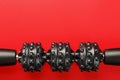 Black lumpy foam body massage roller on red background Royalty Free Stock Photo