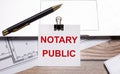 A black luxury pen, documents and a white sheet of paper under a black paper clip with the text of NOTARY PUBLIC on the desktop Royalty Free Stock Photo