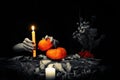 Black magic ritual. Witches hands with sharp long nails hold a candle and little pumpkins among dry herb, nuts, dead Royalty Free Stock Photo