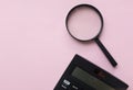 Copy space black magnifying glass and calculator on pink pastel background.Business and finanse concept Royalty Free Stock Photo