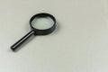 Black magnifying glass on a light gray surface, ready for use in various tasks Royalty Free Stock Photo