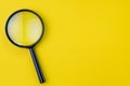 Black magnifying glass, magnifier on yellow background with copy