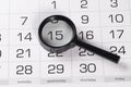 Black magnifying glass over calendar