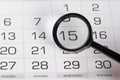 Black magnifying glass over calendar