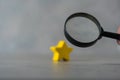 A black magnifying glass with a yellow star. The concept of finding the star, find a new actor. Hiring and recruitment selection