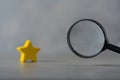 A black magnifying glass with a yellow star. The concept of finding the star, find a new actor. Hiring and recruitment selection