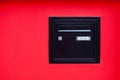 Black mailbox incrusted in a red wall