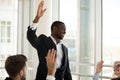 Black male coach hold teambuilding activity with workers raising