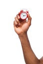 Black male hand holding red alarm clock