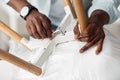 Black male hands with smartwatch screwing detail to chair with wrench, closeup, cropped Royalty Free Stock Photo