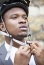 Black male model cyclist tying his helmet