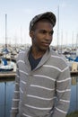 Black male model wearing sweater and newsboy hat at waterfront