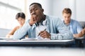 Black male student yawning sitting at desk in class Royalty Free Stock Photo