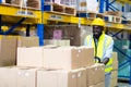 Black Male warehouse worker pulling a pallet truck. middle aged African American warehouse worker preparing a shipment in large Royalty Free Stock Photo