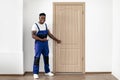 Black Male Worker Pointing Finger At New Entry Door Indoors Royalty Free Stock Photo