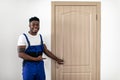 Black Male Worker Pointing At New Door After Installation Indoors Royalty Free Stock Photo