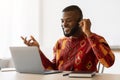 Black Man In African Shirt Making Video Call With Laptop And Headset Royalty Free Stock Photo