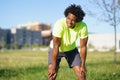 Black man with afro hair exhausted after exercising.