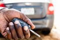Black man`s hand presses on the remote control car alarm systems. A African American man`s hand holding car keys and a remote cont