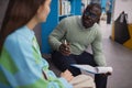 Black man as mental health specialist talking to teenage girl in therapy session Royalty Free Stock Photo