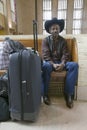 Black man with bags, cowboy hat and cowboy shoes waiting for train at 30th Street Station, AMTRAK Train Station in Philadelphia