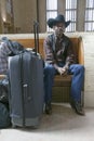 Black man with bags, cowboy hat and cowboy shoes waiting for train at 30th Street Station, AMTRAK Train Station in Philadelphia