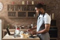 Black man baking pastry with recipe on laptop Royalty Free Stock Photo