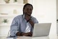 Black Man Browsing Internet On Laptop While Sitting At Desk At Home Royalty Free Stock Photo