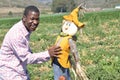 Black man in a California farm playing with a scarecrow Royalty Free Stock Photo