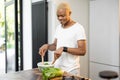 Black man cooking organic salad at home kitchen