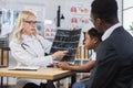 Black man with daughter listening doctor's advice at clinic Royalty Free Stock Photo