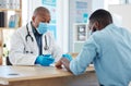 Black man, doctor and mask consulting patient for healthcare prescription or covid diagnosis at hospital. African male Royalty Free Stock Photo