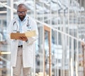 Black man, doctor and reading notes on clipboard with research documents, healthcare schedule or test results in Royalty Free Stock Photo