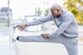 Black man doing stretching before running in urban background Royalty Free Stock Photo