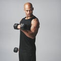 Black man, dumbbells and fitness in studio, bicep and muscle progress or arm on gray background. Male person, sports and Royalty Free Stock Photo