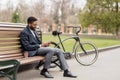 Black man in earphone sitting on bench listening to radio Royalty Free Stock Photo