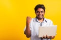 Black man excited holding laptop computer clenching fists and raising a hand for winner Royalty Free Stock Photo