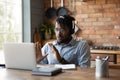 Black man expert in headphones assist client online using laptop Royalty Free Stock Photo