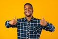 Black Man Gesturing Thumbs Up With Both Hands, Yellow Background Royalty Free Stock Photo