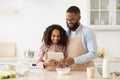 Black man and girl cooking in the kitchen reading recipe Royalty Free Stock Photo