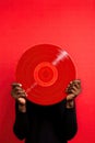 Black man hand holding old vinyl retro record. Vinyl gramophone record on red background. Royalty Free Stock Photo